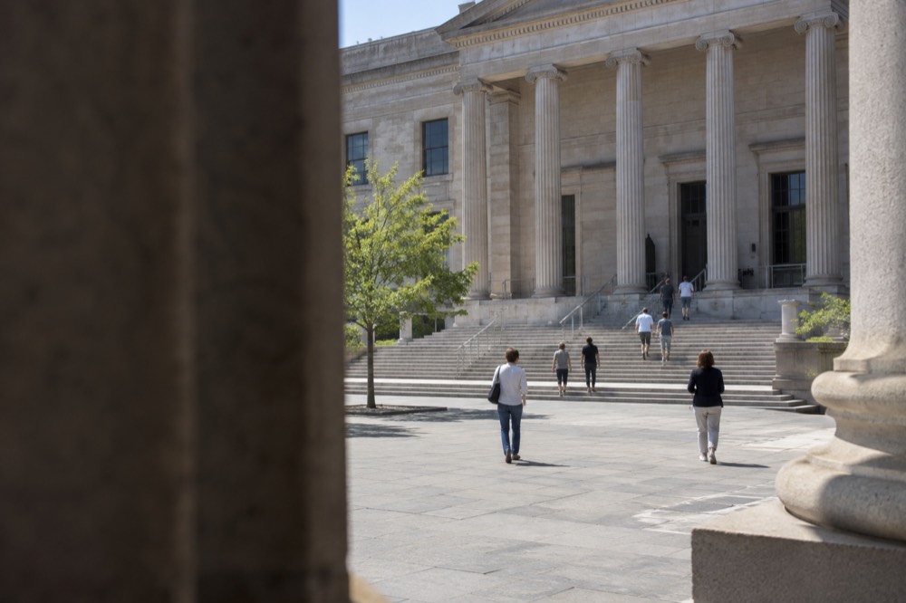 The stone facade of a large classical museum building with wide steps and columns at street level