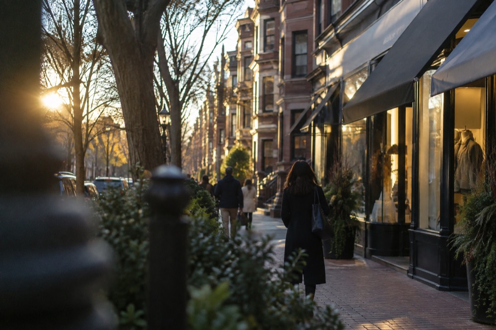 Shop windows and awnings along a brick shopping street in Back Bay