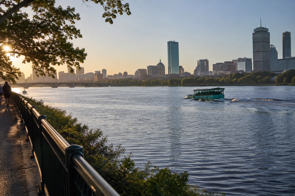Amphibious duck boat vehicle crossing the Charles River with the Boston skyline behind it