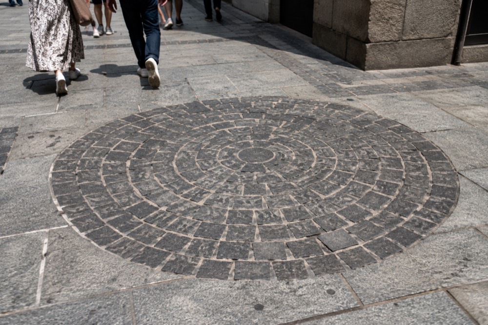 A circle of dark cobblestones marking the Boston Massacre site set into the pavement of State Street