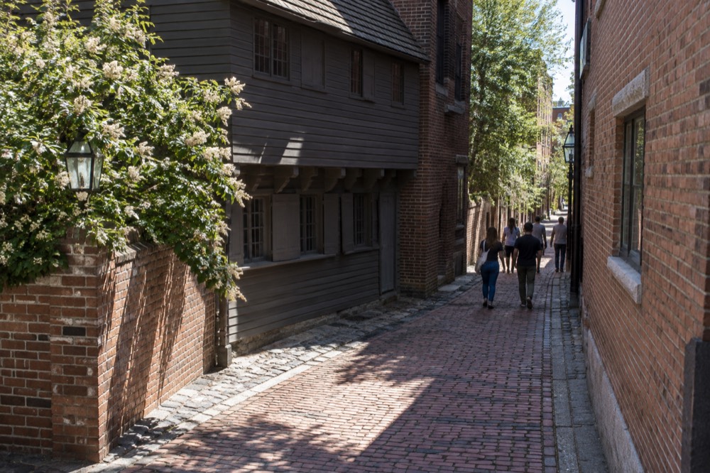 Visitors walking a narrow brick lane in Boston's North End