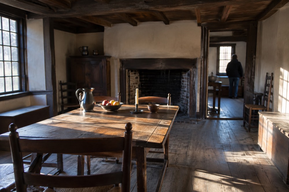 A low-ceilinged colonial room with period furniture and exposed beams