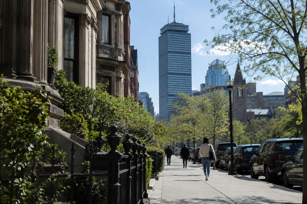 The Prudential Center tower rising above the Back Bay street grid seen from below
