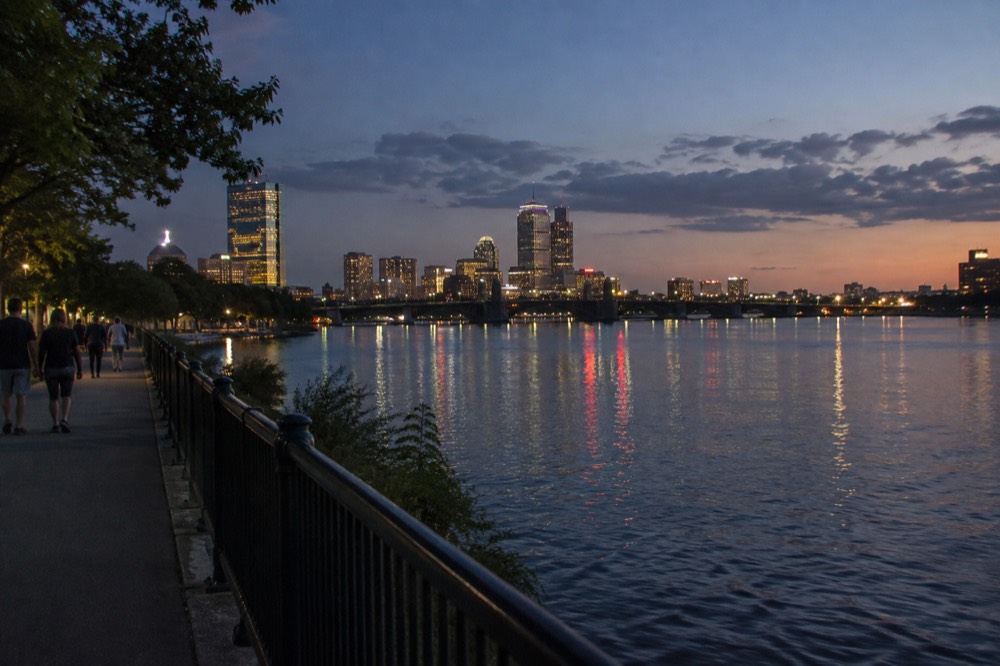 Night falling over Boston with building lights reflecting in the Charles River seen from above
