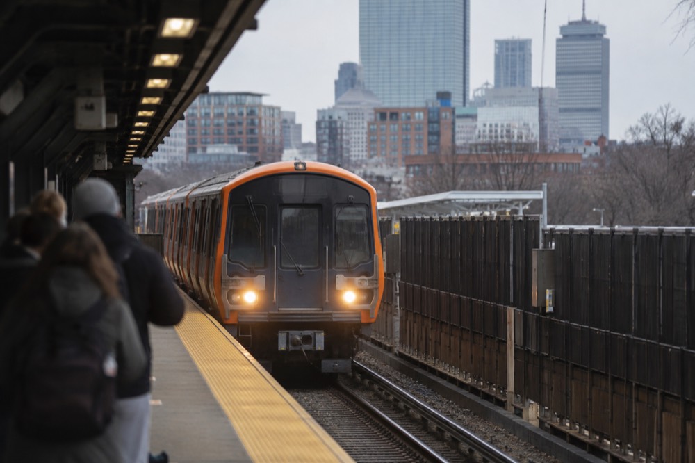 An Orange Line subway train arriving at a Boston station platform