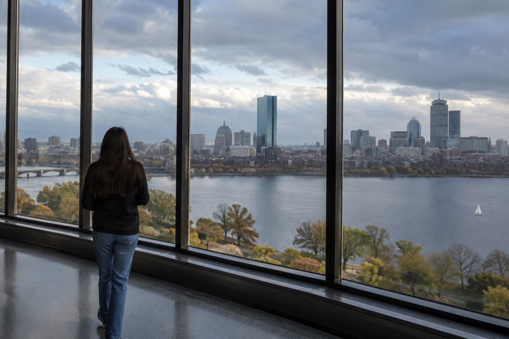 Observation deck windows high above the Boston skyline with the Charles River and downtown towers in view