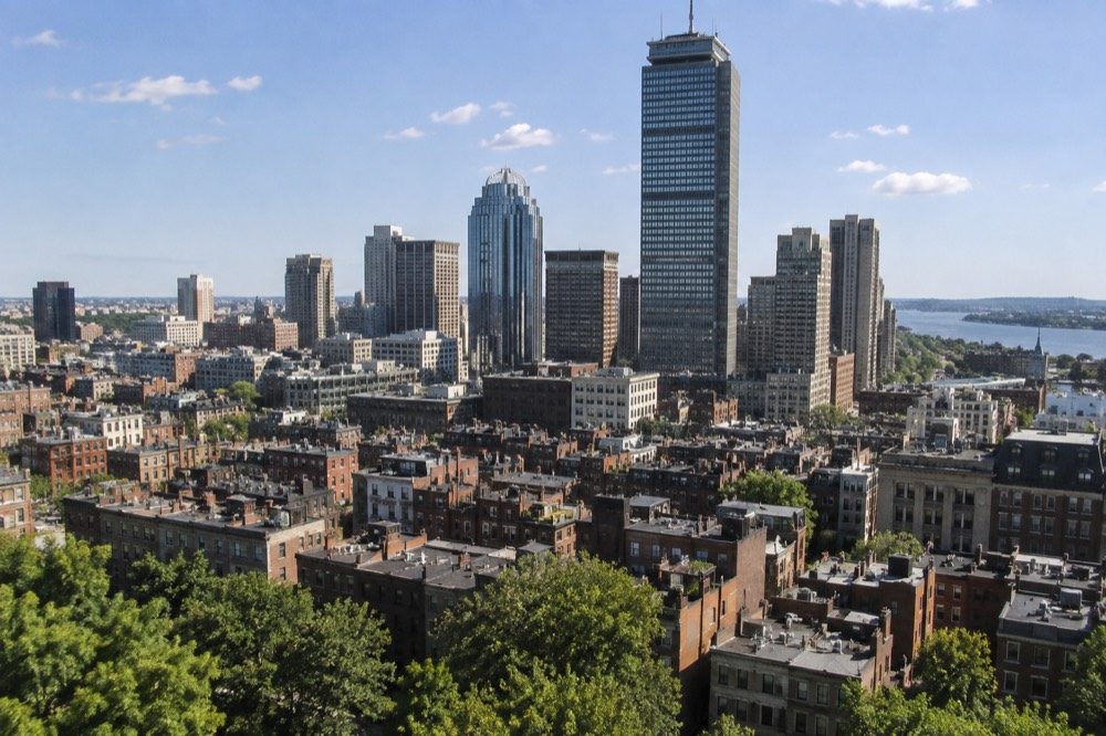 The Prudential Center tower rising above the low rooftops of the Back Bay on a clear afternoon