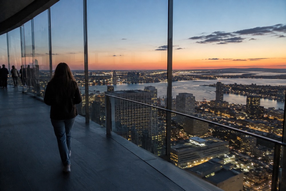 Evening city lights spreading across the Boston grid as seen from a high observation deck