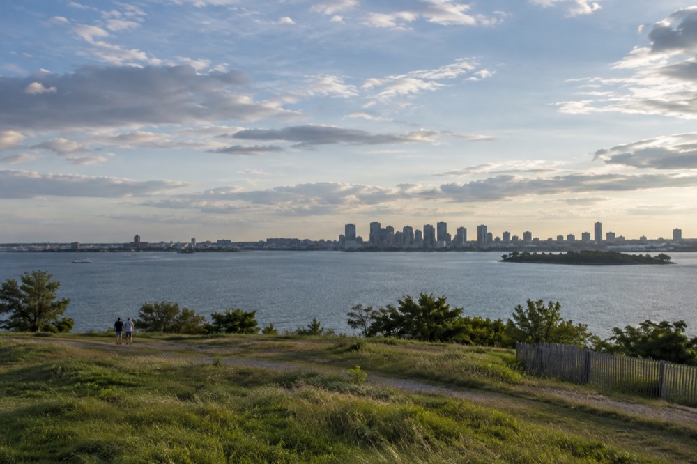 The Boston skyline seen across harbor water at late afternoon from an island hilltop