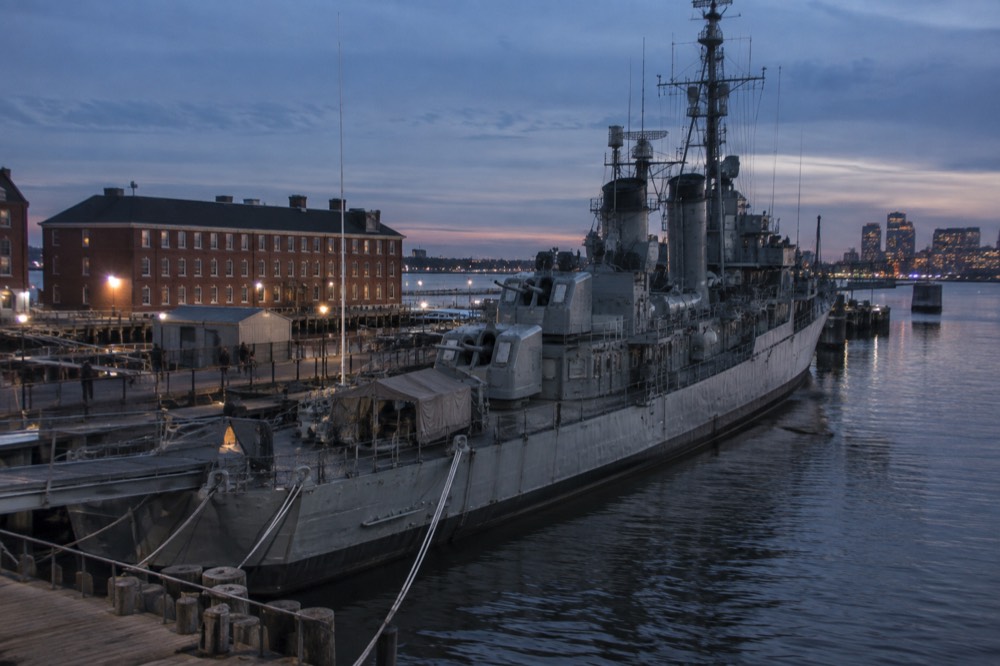 The gray steel hull of the destroyer USS Cassin Young moored near the USS Constitution
