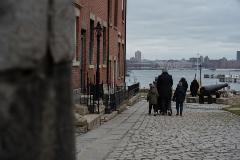 Families walking between historic buildings in the Charlestown Navy Yard