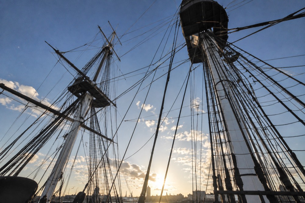The USS Constitution's rigging and masts against a late afternoon sky