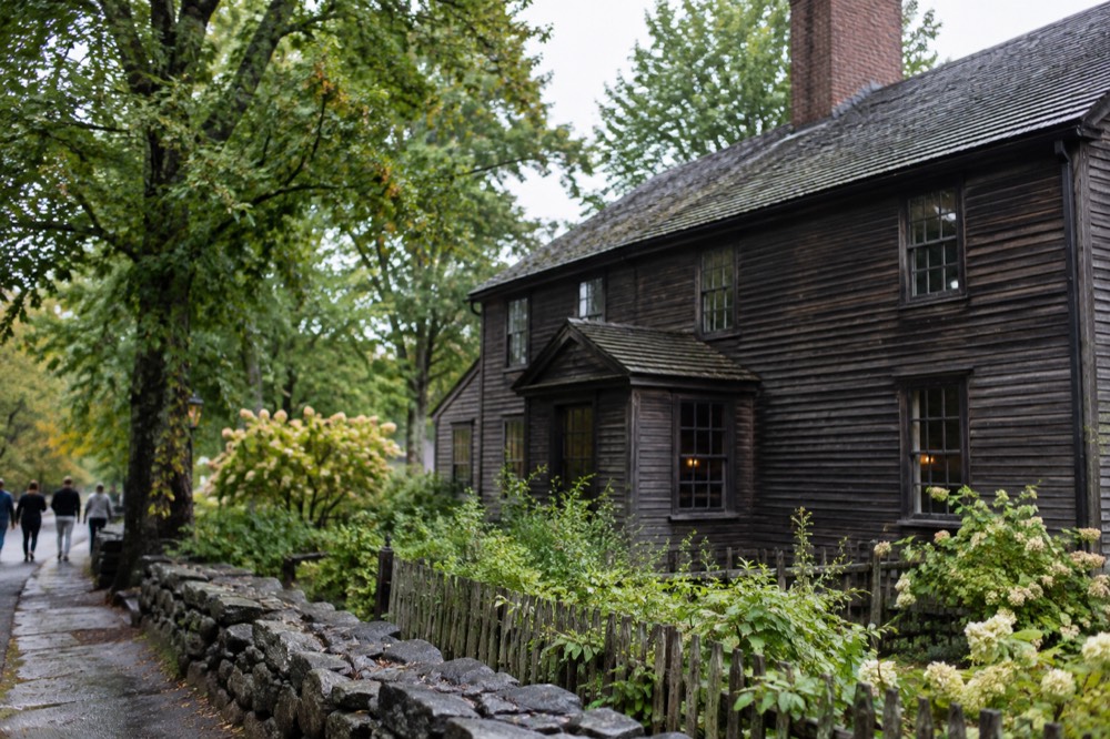A historic wooden tavern building with a chimney and small-paned windows