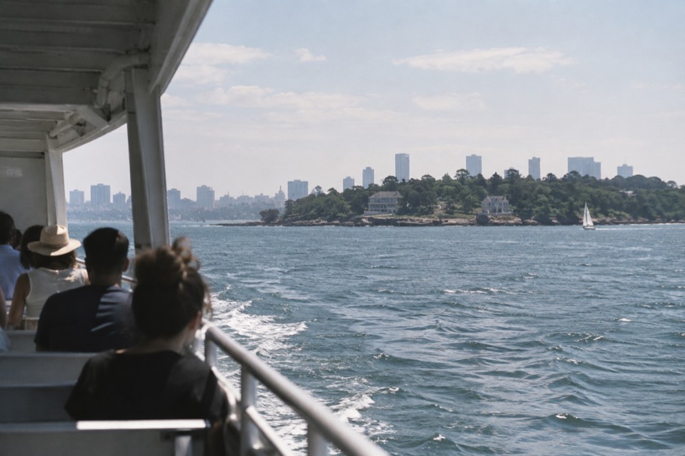 A ferry crossing open water toward a New England island shoreline