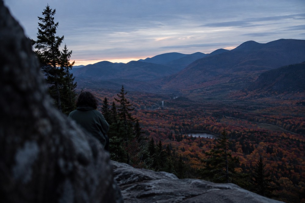 A mountain valley in New Hampshire covered in red and orange autumn forest