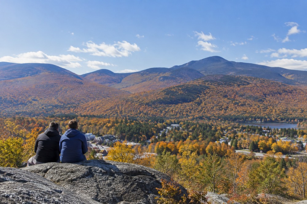 Rolling hills in western Massachusetts covered in mixed autumn color with a small town below