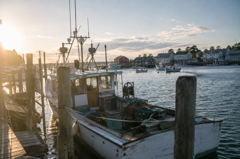 A wooden fishing boat moored in a small New England harbor