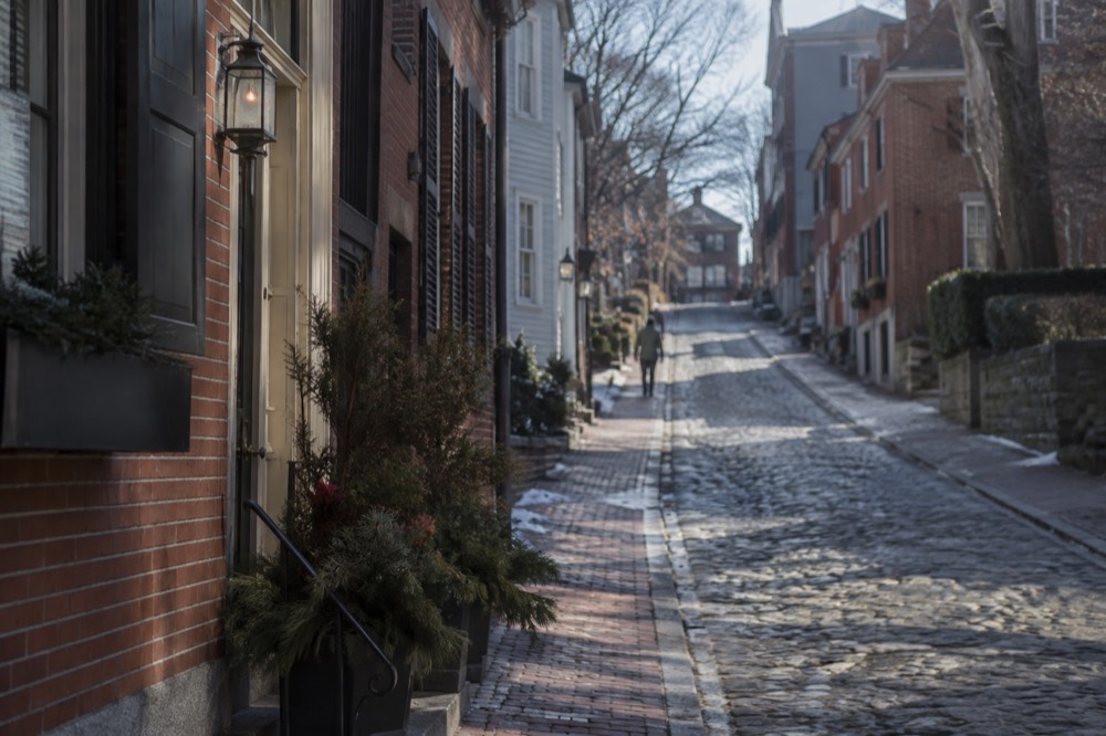 Historic brick street climbing a hill lined with colonial-era houses
