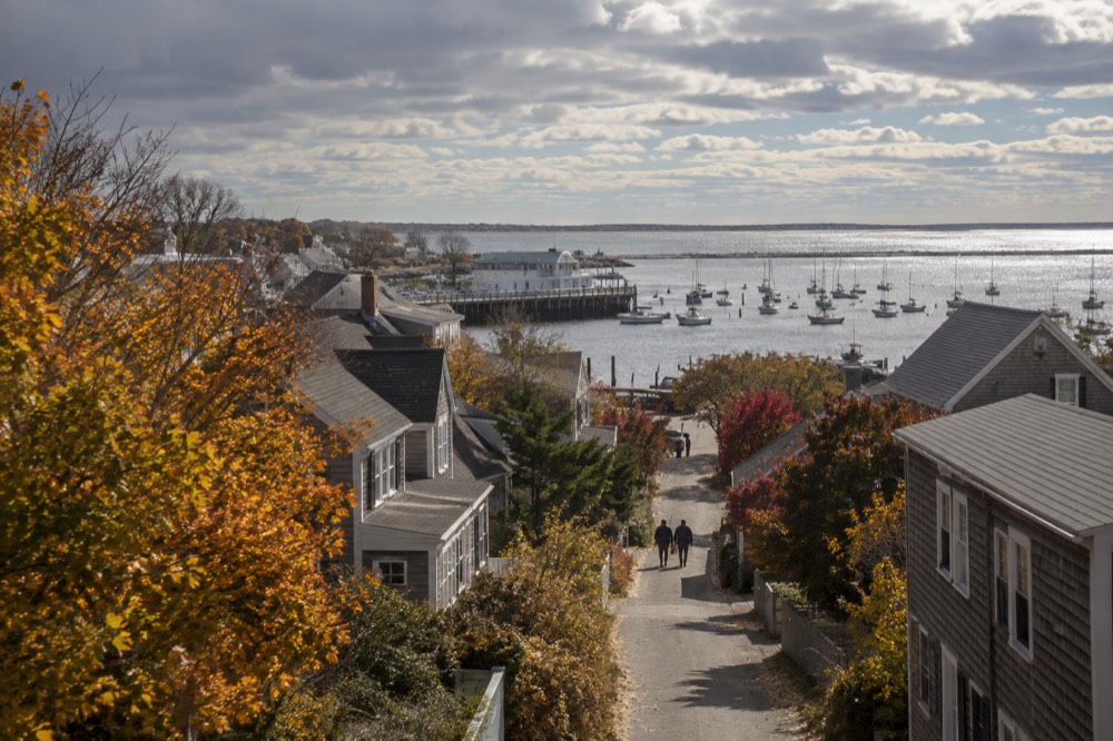 Autumn light over Provincetown harbor with empty streets and moored boats