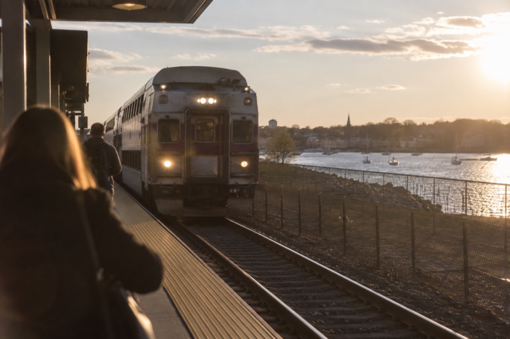 Commuter rail train arriving at a small New England station platform