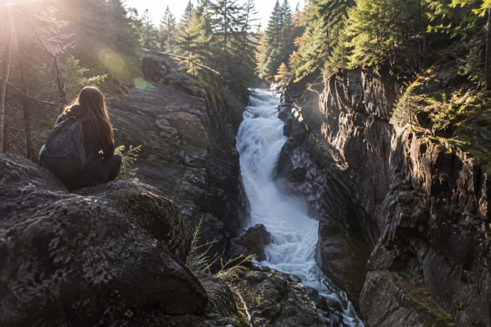 A waterfall dropping between steep rock walls in a mountain gorge