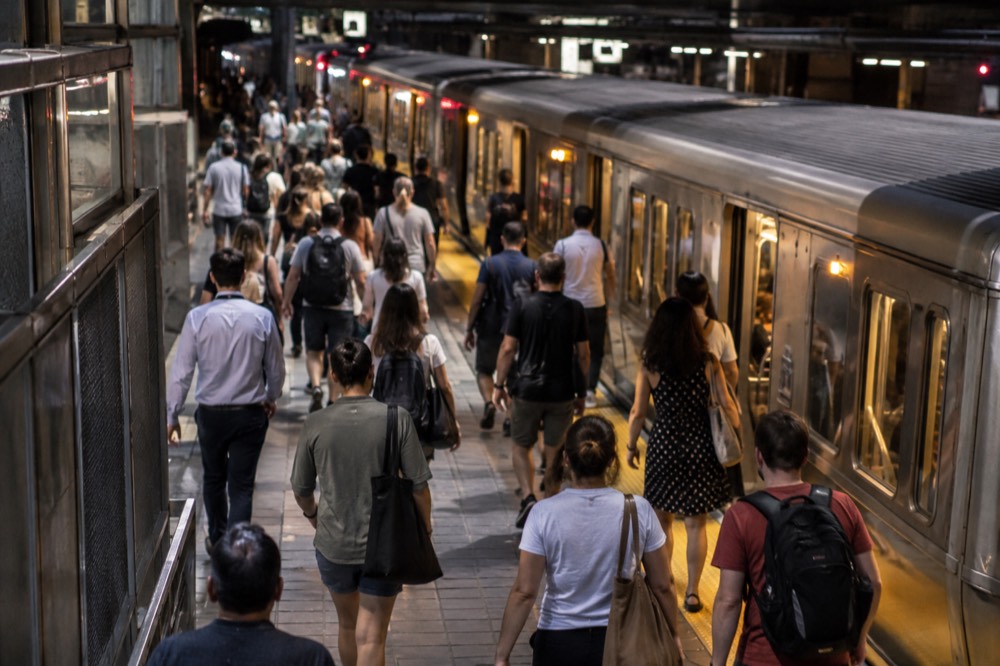 A crowded MBTA subway platform in Boston with trains arriving in the evening