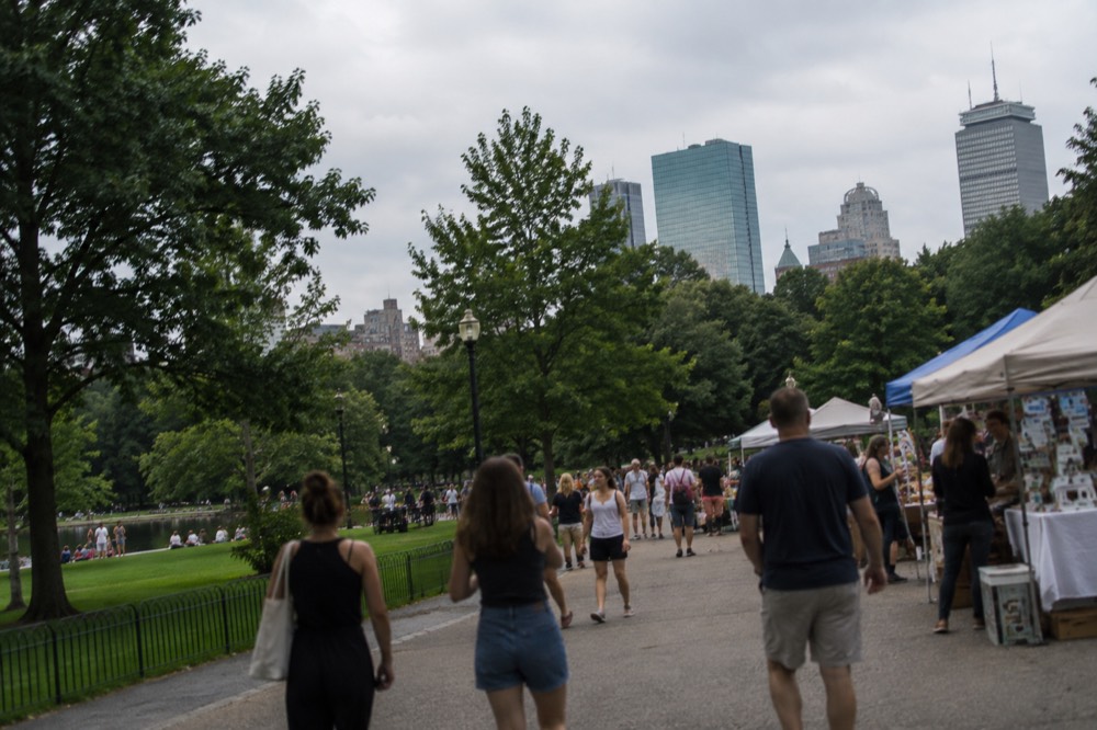 Crowds walking through a busy Boston marketplace in summer