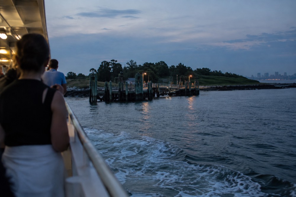 A ferry approaching a Boston Harbor island dock in summer