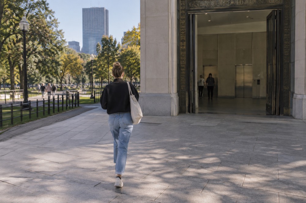 A wide museum gallery entrance with a level threshold and elevator doors visible