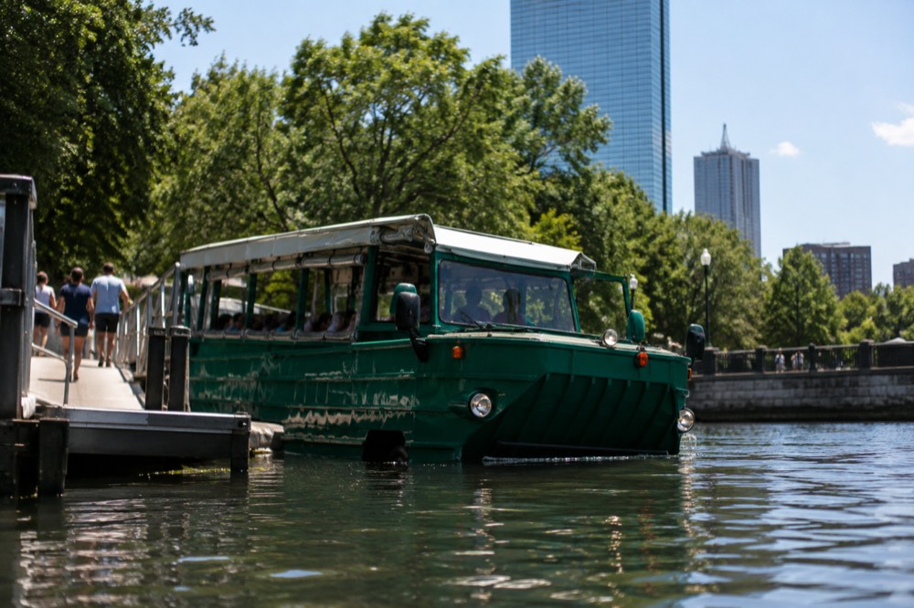 An amphibious tour vehicle at a dockside boarding area with a ramp