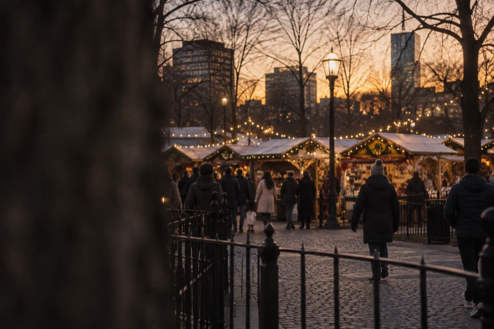 Holiday lights strung over a cobblestone marketplace plaza at dusk