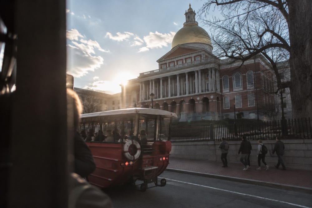 A duck boat passing the Massachusetts State House on Beacon Hill during the street portion of a tour
