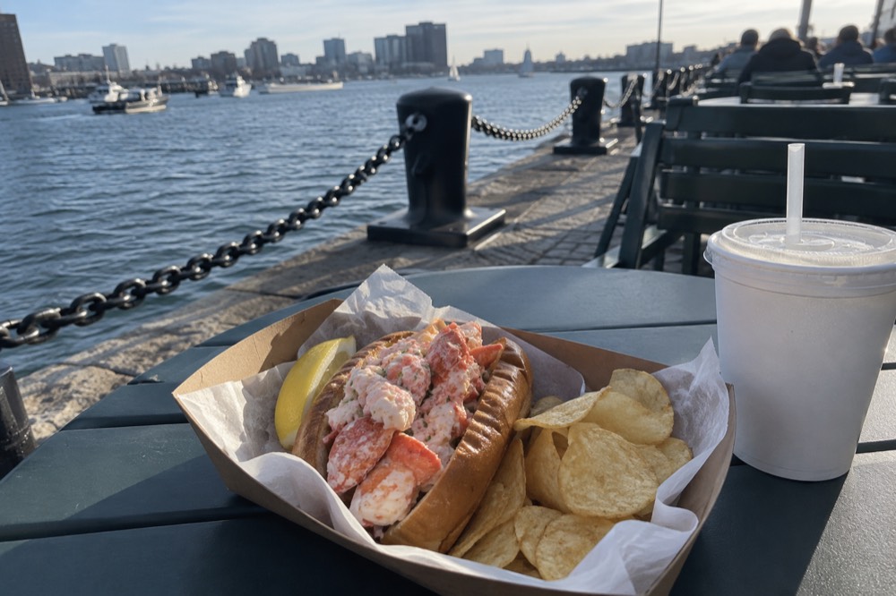 A lobster roll served at an outdoor table near the Boston waterfront