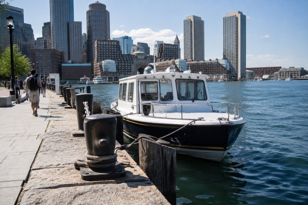 A small water taxi boat tied up at a downtown Boston pier