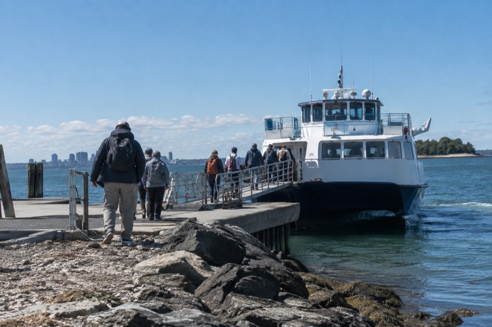Passengers boarding a ferry at a Boston Harbor island landing