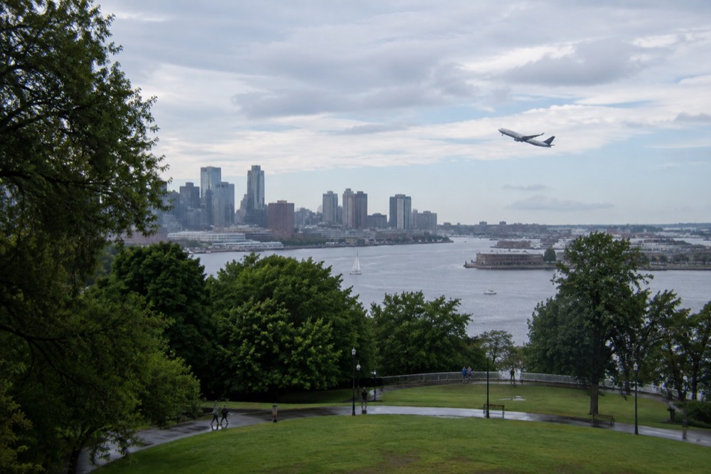 A plane taking off over Boston Harbor with the city skyline beyond