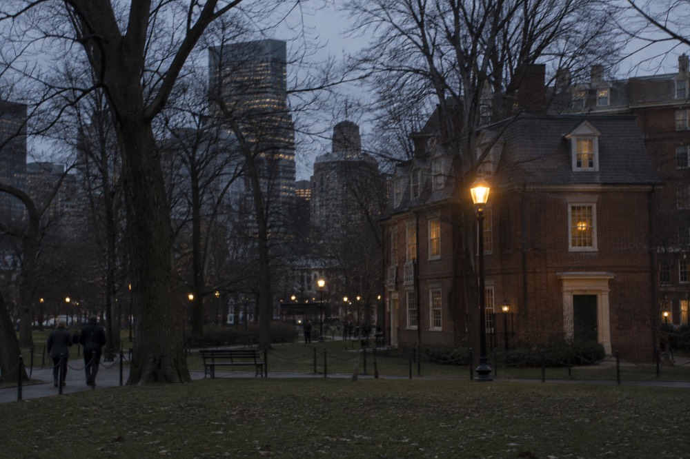 A brick colonial building facade lit by a single streetlamp at night