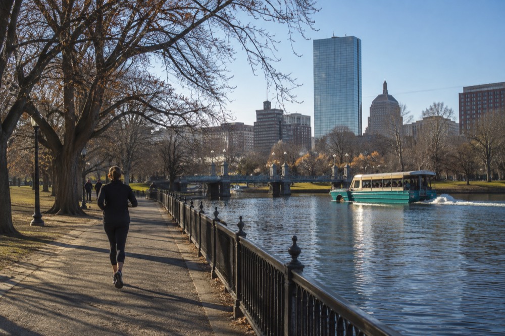 An amphibious tour vehicle driving past historic Boston buildings in daylight