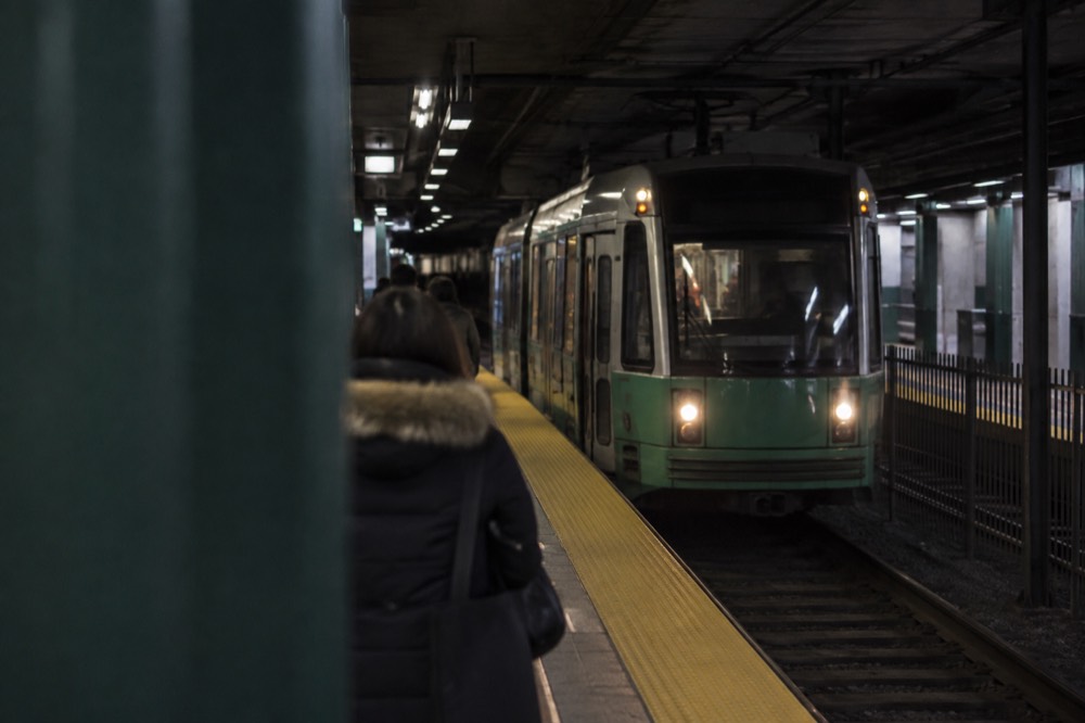 A Green Line trolley arriving at an underground MBTA station platform