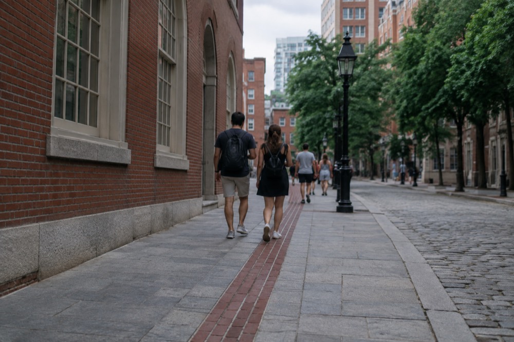 Visitors walking the red line of the Freedom Trail past historic brick buildings