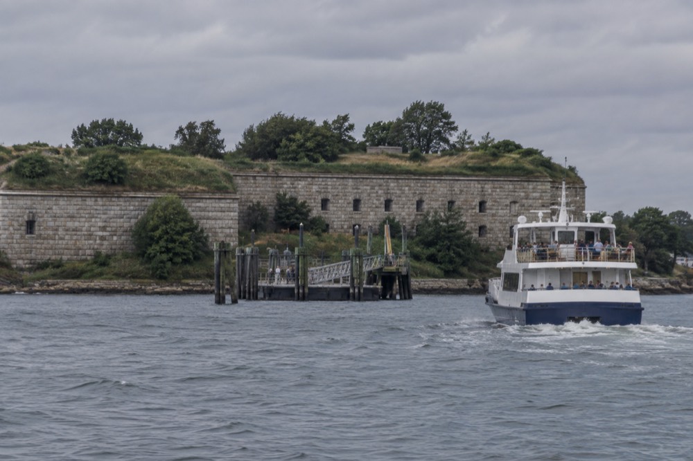 A ferry approaching Georges Island with Fort Warren's granite walls visible