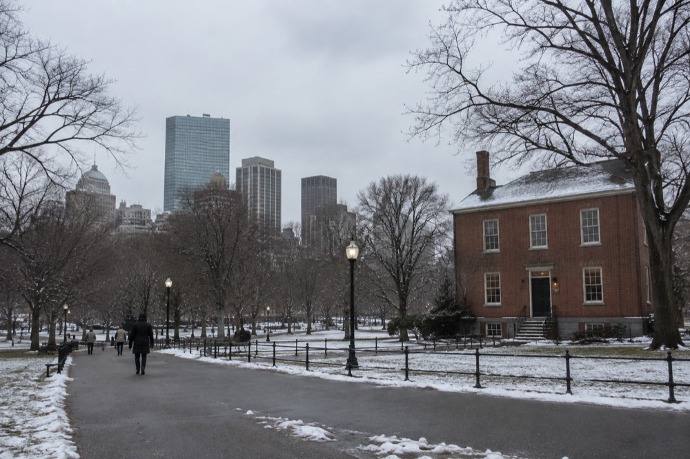 A red brick colonial building with a dusting of snow on the sidewalk outside