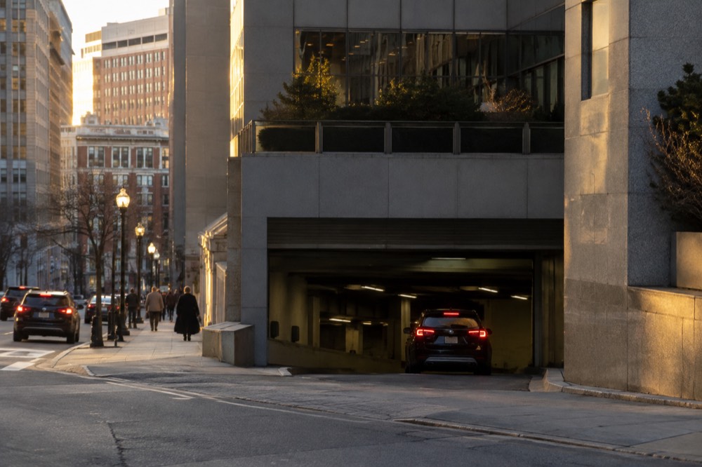 A parking garage entrance on a downtown Boston street with tall buildings above