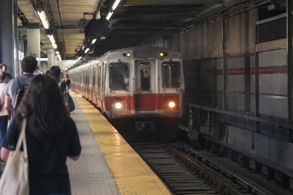 An MBTA subway train arriving at a platform inside a Boston station