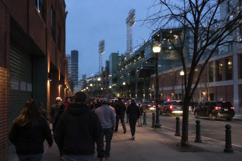 Fenway Park's exterior with crowds walking along the street on a game day