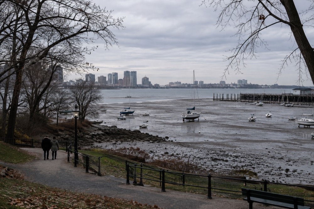 A Boston harbor view at low tide with boats resting on exposed flats near a pier