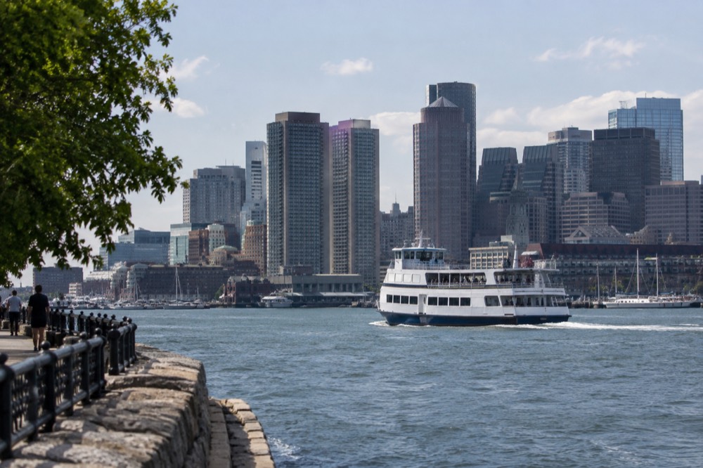 A ferry crossing Boston Harbor with the city skyline behind it