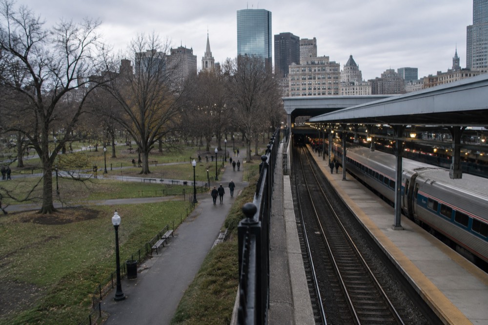 An Amtrak train waiting at a platform inside a busy rail station