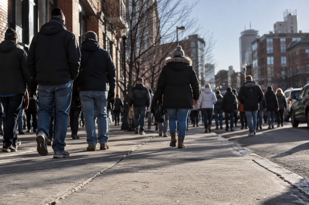 A crowd of baseball fans gathering outside Fenway Park on a sunny afternoon