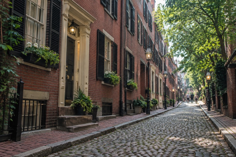 Rowhouses on a narrow brick street in Boston's Beacon Hill neighborhood